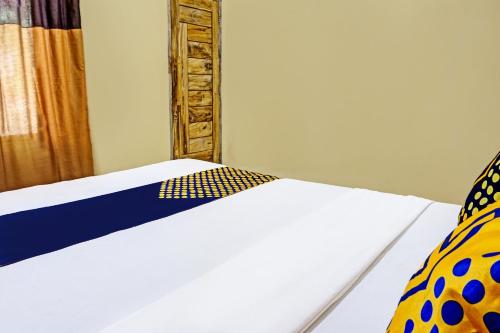 a bedroom with a white bed and a mirror at OYO Life 91988 Azka Homestay Klayar in Pacitan