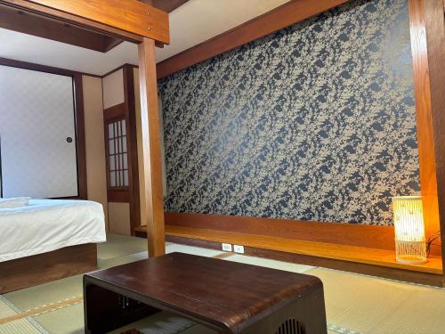 a bedroom with a wall covered in a wallpaper at ホテルオアシスガーデン in Obita