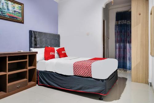 a bedroom with a bed with red pillows on it at OYO Life 91994 Sawerigading Jatinangor Syariah in Sayang