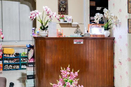 a counter with flowers on it in a store at OYO Life 91994 Sawerigading Jatinangor Syariah in Sayang
