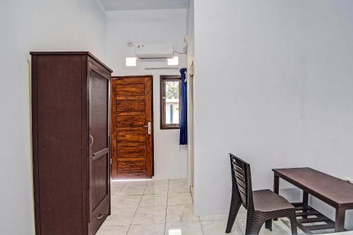 a dining room with a table and a wooden door at Hotel O Cvictory Inn in Manado