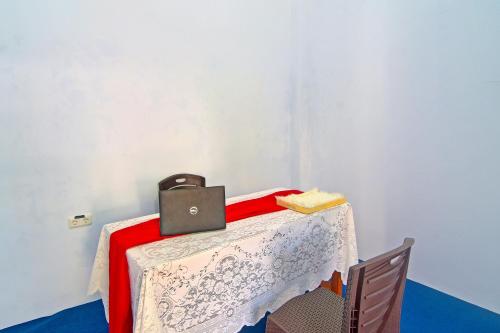 a table with a laptop on top of it at Hotel O Cvictory Inn in Manado