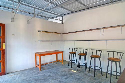 a table and four stools in a room at Hotel O Cvictory Inn in Manado