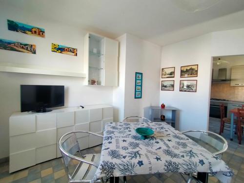 a dining room table with two chairs and a television at La Casa del Marinaio P1 in San Foca