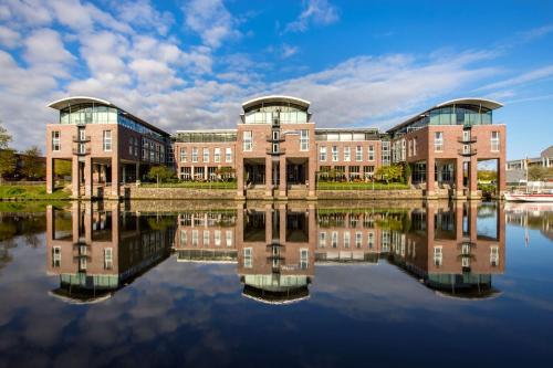 a university building with its reflection in the water at Radisson Blu Senator Hotel, Lübeck in Lübeck