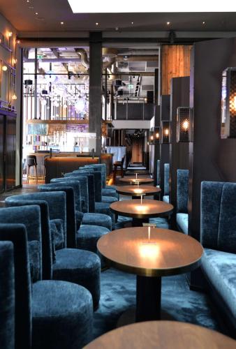 a bar with couches and tables and chairs at Radisson Blu Senator Hotel, Lübeck in Lübeck
