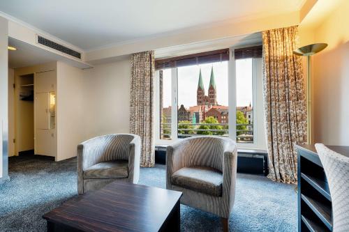 a room with a table and chairs and a large window at Radisson Blu Senator Hotel, Lübeck in Lübeck