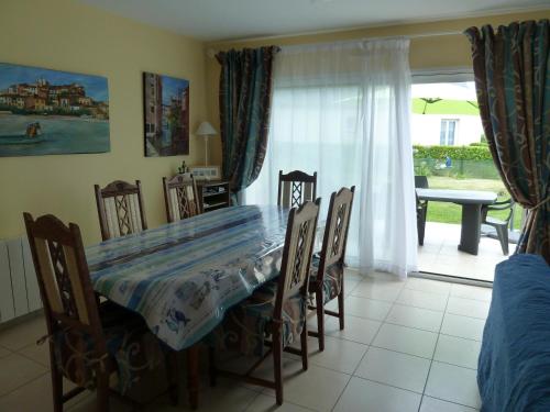 une salle à manger avec une table et des chaises et une fenêtre dans l'établissement VIALA Alain, à Perros-Guirec