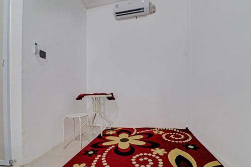 a room with a red rug on a white wall at Hotel O Gala Residence in Jambi