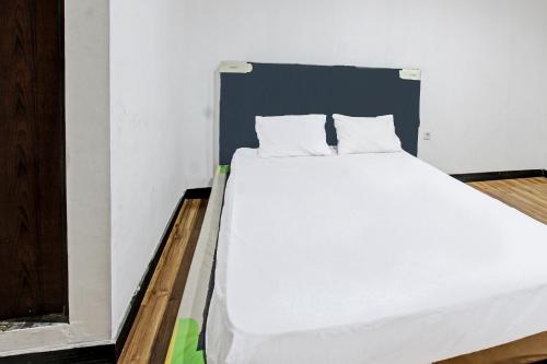 a bed with white sheets and pillows in a room at Hotel O Panorama Rinjani LodgeNearTaman Nasional Gunung Rinjani in Labuan Lombok