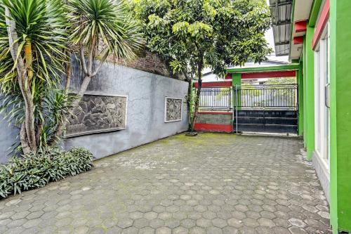 an empty courtyard with trees and a building at Hotel O Fun Guesthouse Syariah in Mojokerto