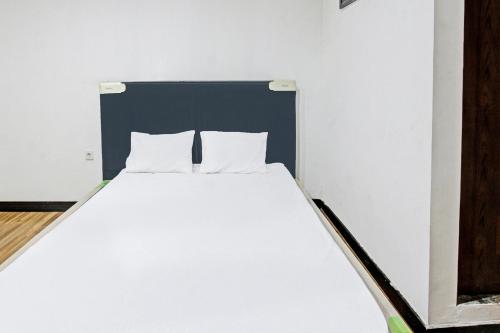 a white bed with two pillows in a room at Hotel O Panorama Rinjani LodgeNearTaman Nasional Gunung Rinjani in Labuan Lombok