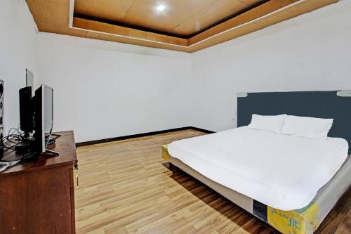 a bedroom with a bed and a tv in it at Hotel O Panorama Rinjani LodgeNearTaman Nasional Gunung Rinjani in Labuan Lombok