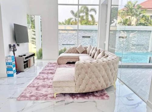 a living room with a large couch and a table at Luxury Pool Villa 99 in Ban Bang Krang