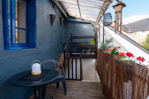 a table and a chair on a balcony at Gite du Canal in Josselin
