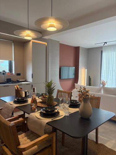 a dining room and living room with a table and chairs at Maya Suites Potidaia in Nea Potidaea