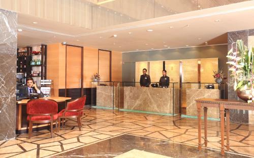 a lobby with two people sitting at a table at Radisson Blu Hotel Chennai City Centre in Chennai