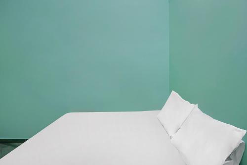 a stack of white pillows on a blue background at Hotel O Homestay Bude Sri in Batam Center