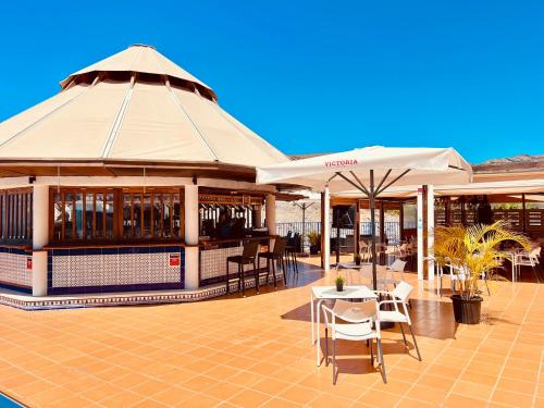 a restaurant with tables and umbrellas on a patio at Sunset Taurito in Taurito