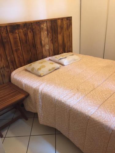 - un lit avec 2 oreillers à côté d'une table dans l'établissement Quadrale, à Sotta