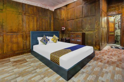 a bedroom with a bed and wooden walls at OYO 92083 Lailik Gilang Guesthouse in Watukarung