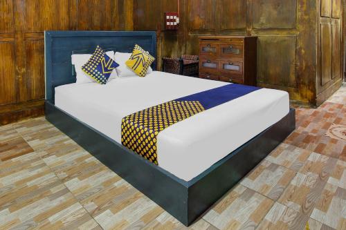a bedroom with two beds and a wooden floor at OYO 92083 Lailik Gilang Guesthouse in Watukarung