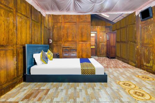 a bedroom with a bed in a room with wooden walls at OYO 92083 Lailik Gilang Guesthouse in Watukarung