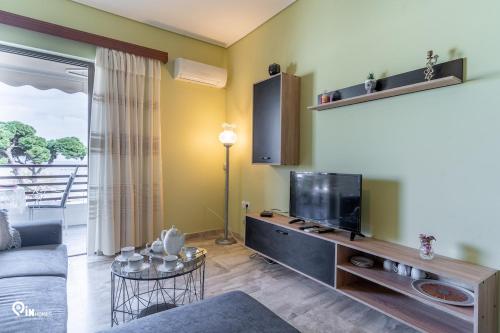a living room with a tv and a couch at 'Nefeli' House With Amazing View Βy The Sea in Nea Makri