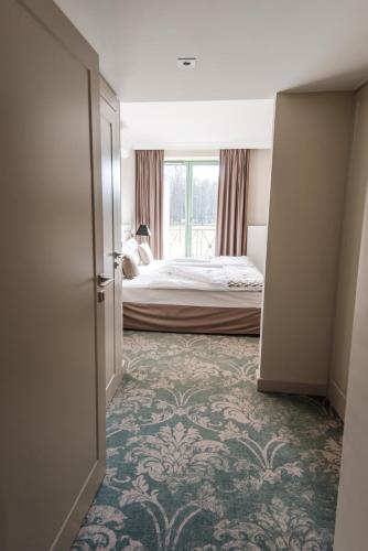 a bedroom with a bed and a window and a door at Parkowa Sypialnia in Rozalin