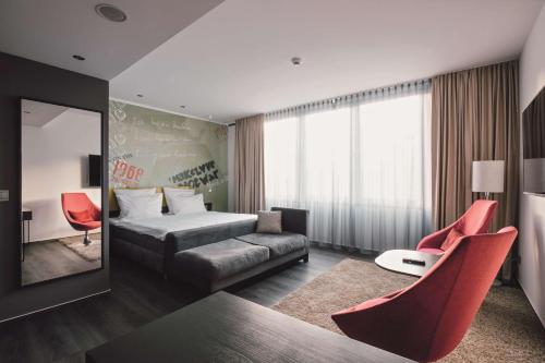 ein Hotelzimmer mit einem Bett und roten Stühlen in der Unterkunft Hotel Berlin, Berlin, a member of Radisson Individuals in Berlin