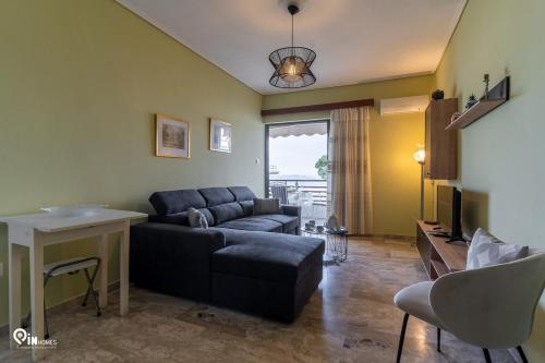 a living room with a couch and a table at 'Nefeli' House With Amazing View Βy The Sea in Nea Makri