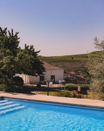 a villa with a swimming pool in front of a house at Casal de Tralhariz - Douro Valley in Tralhariz