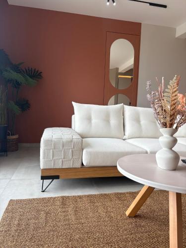 a living room with a white couch and a table at Maya Suites Potidaia in Nea Potidaea