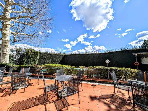 a patio with tables and chairs on a brick patio at Residence Villa La Fornacina in Incisa in Valdarno
