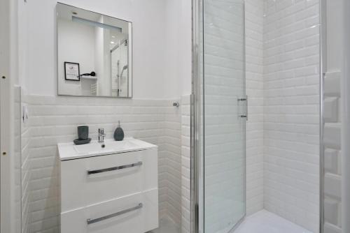 a white bathroom with a sink and a shower at Studio confort Equipé & Connecté - 1 - Mon Groom in Troyes