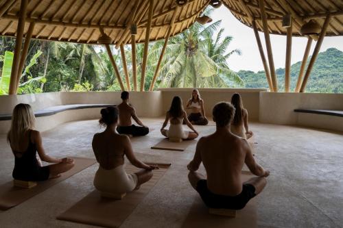 a group of people sitting in a yoga class at Neano Escape in Candidasa