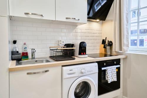 une cuisine avec une machine à laver et un évier dans l'établissement Studio confort Equipé & Connecté - 1 - Mon Groom, à Troyes