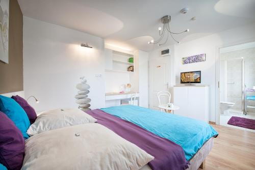 a bedroom with a bed with a colorful blanket at A. V. Pension Praha in Prague