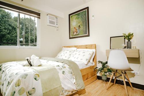 a bedroom with a bed and a desk and a chair at AR09 HBRentals 1BR Smart Unit in Davao City