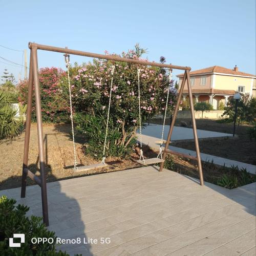 a swing set in a yard with a wooden deck at Casa di Cetty in Butera