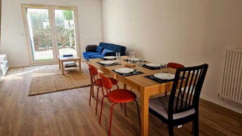 - une salle à manger avec une table, des chaises et un canapé dans l'établissement Paul Eluard - Maison au calme parking centre Tours, à Tours