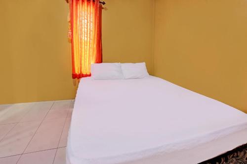 a white bed in a room with a window at Hotel O Ujung Samalas HomestayNearLapangan Sembalun Bumbung in Labuan Lombok