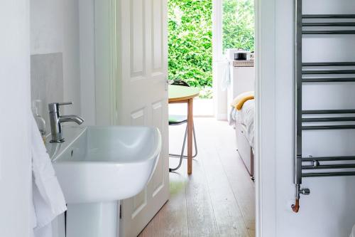 a white bathroom with a sink and a table at New Snug DoubleEnsuite in Central Forest Row in Forest Row