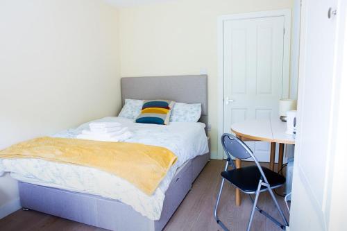 a bedroom with a bed and a table with chairs at New Snug DoubleEnsuite in Central Forest Row in Forest Row