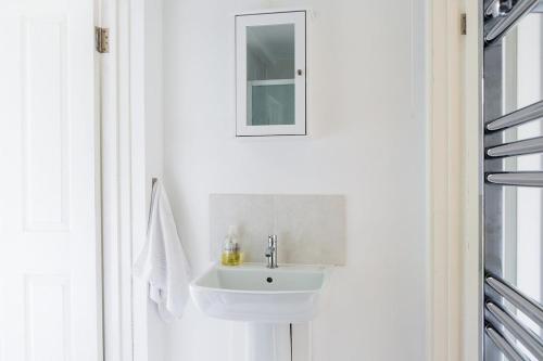 a white bathroom with a sink and a mirror at New Snug DoubleEnsuite in Central Forest Row in Forest Row