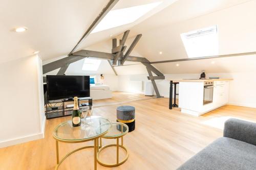 un salon avec une table en verre et une télévision dans l'établissement Nid douillet sous les combles, à Châlons-en-Champagne
