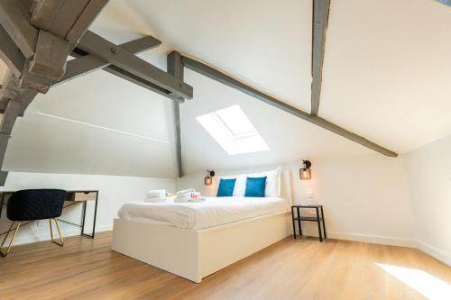 a bedroom with a bed and a desk in it at Nid douillet sous les combles in Châlons-en-Champagne