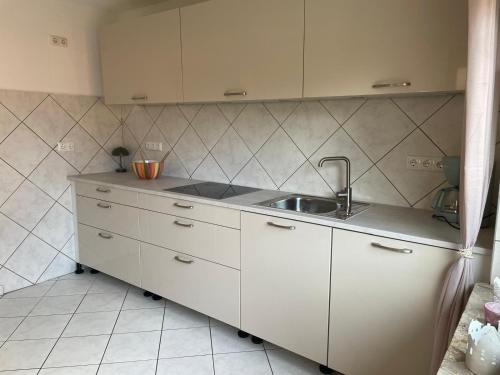 a kitchen with white cabinets and a sink at Friedas Glück in Dannenberg