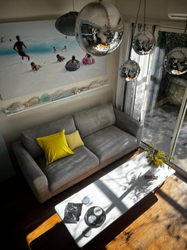 d'un salon avec un canapé et un tableau de personnes dans l'eau. dans l'établissement cabanon chasselon, à Marseille