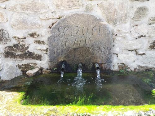 a fountain in a stone wall with some water in it at Mar de Nubes Piornal 3 in Piornal